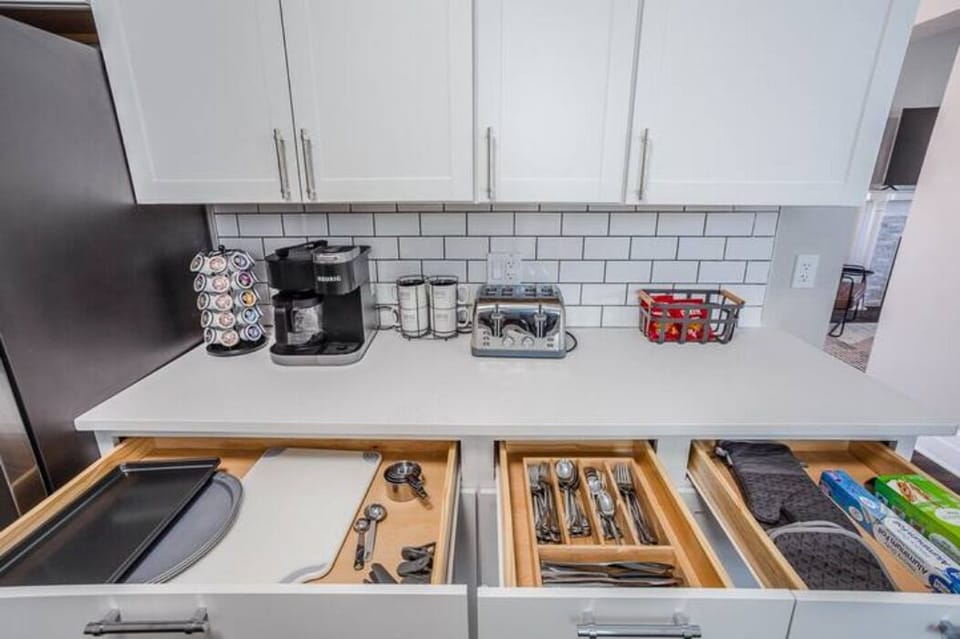Fully stocked kitchen with utensils, cooking supplies, cutting board, pots &pans