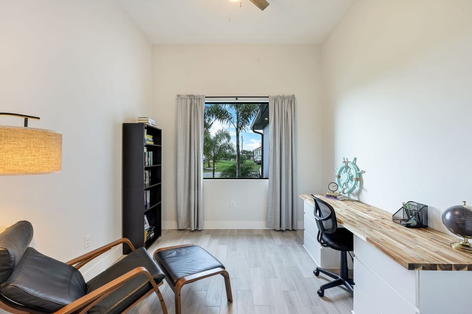 Office with large, spacious desk & bookshelf full of a variety of holiday reads