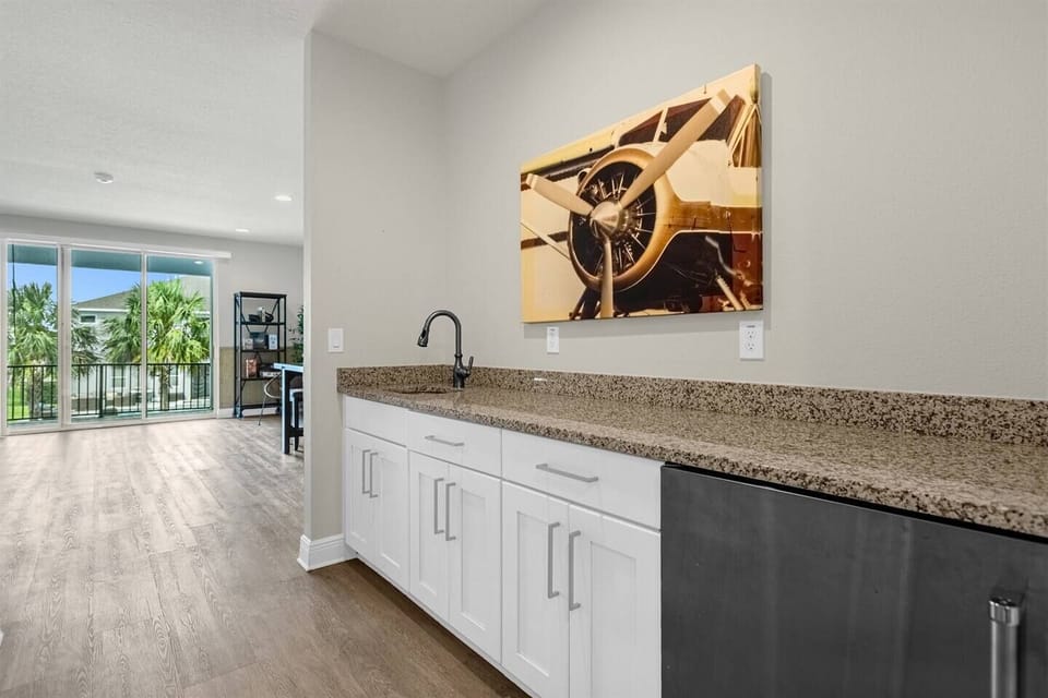 Stylish kitchen featuring a long granite countertop with a sleek sink underneath. The cabinets above the sink provide ample storage, while modern appliances and elegant finishes create a functional and inviting space for cooking and gathering.