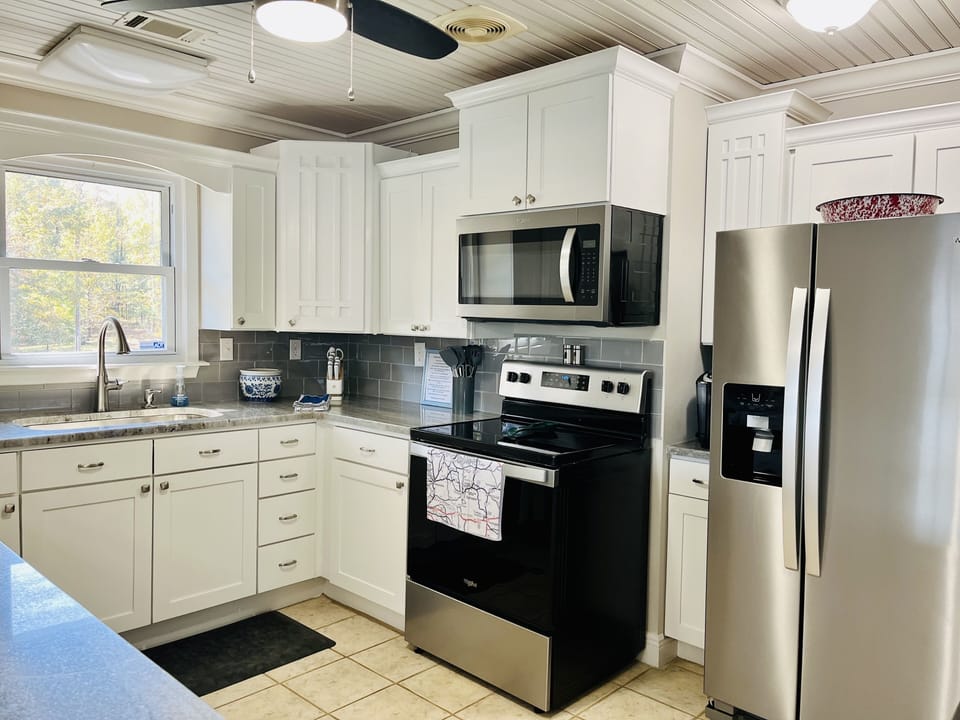 The bright kitchen has top of the line appliances, quartz countertops and views.
