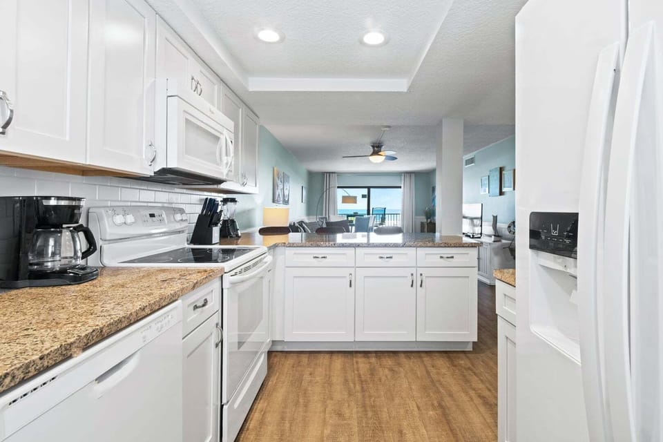 Bright and stylish kitchen featuring white cabinetry, sleek countertops, and ample space.