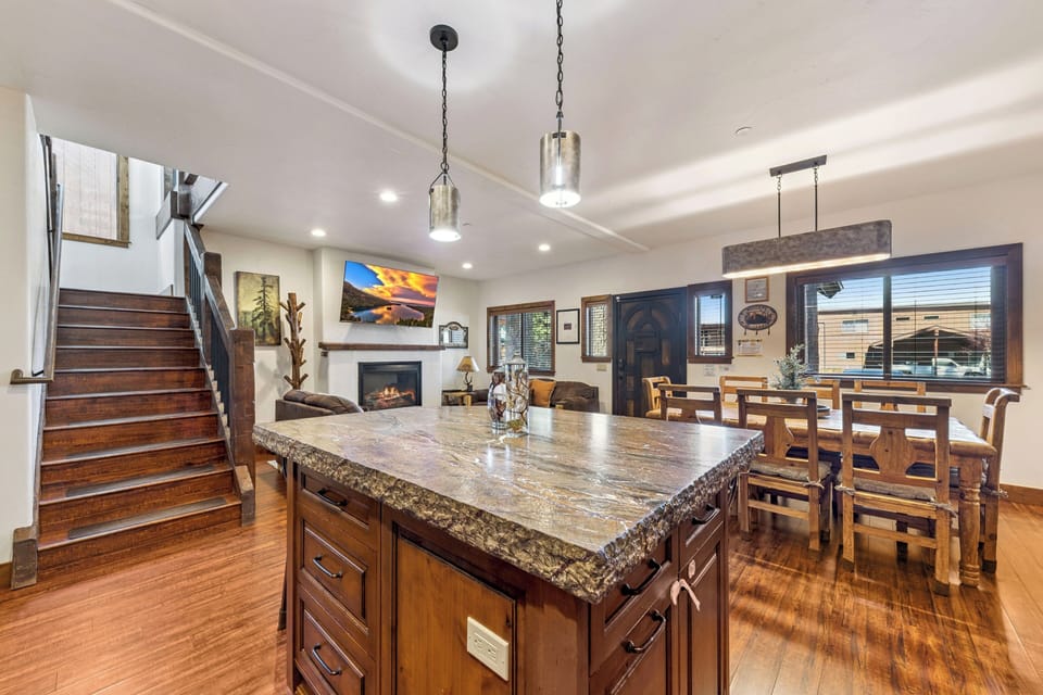 First-floor kitchen and dining area with a spacious stone island, cozy fireplace lounge, and easy access to the bedrooms upstairs