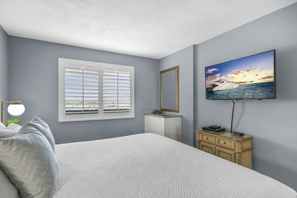 Drift into peaceful sleep in your serene bedroom, where soft blue walls and crisp white linens create the perfect retreat.
