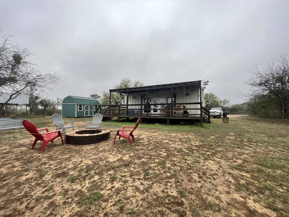 The backyard features a large deck with outdoor seating & 2 hammocks & fire pit.