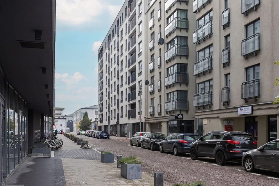 The surrounding area of the apartment building, showcasing a bustling yet clean street lined with modern architecture.