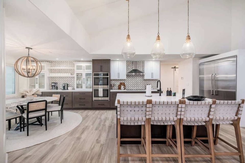 Gather with loved ones in your gourmet kitchen featuring elegant pendant lighting, a spacious island, and modern appliances designed for memorable meals together.