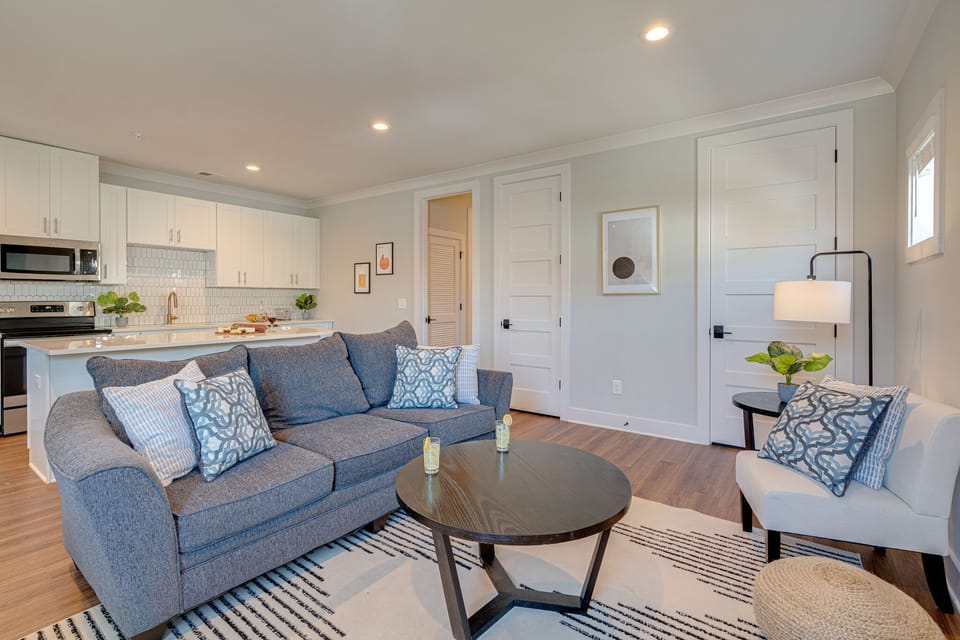 1st Unit: Modern Living Space featuring designer furnishings and a flat-screen SMART TV overlooking the fully equipped kitchen.