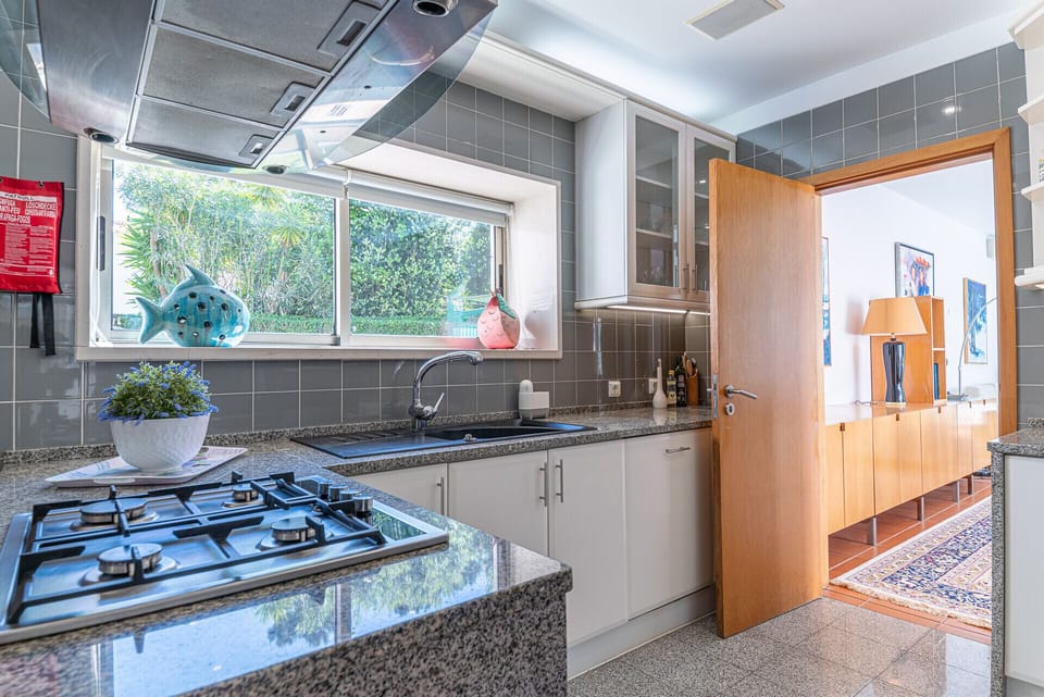 Modern kitchen with gas cooktop and grey tile backsplash — Villa Aroeira II, holiday villa in Herdade de Aroeira