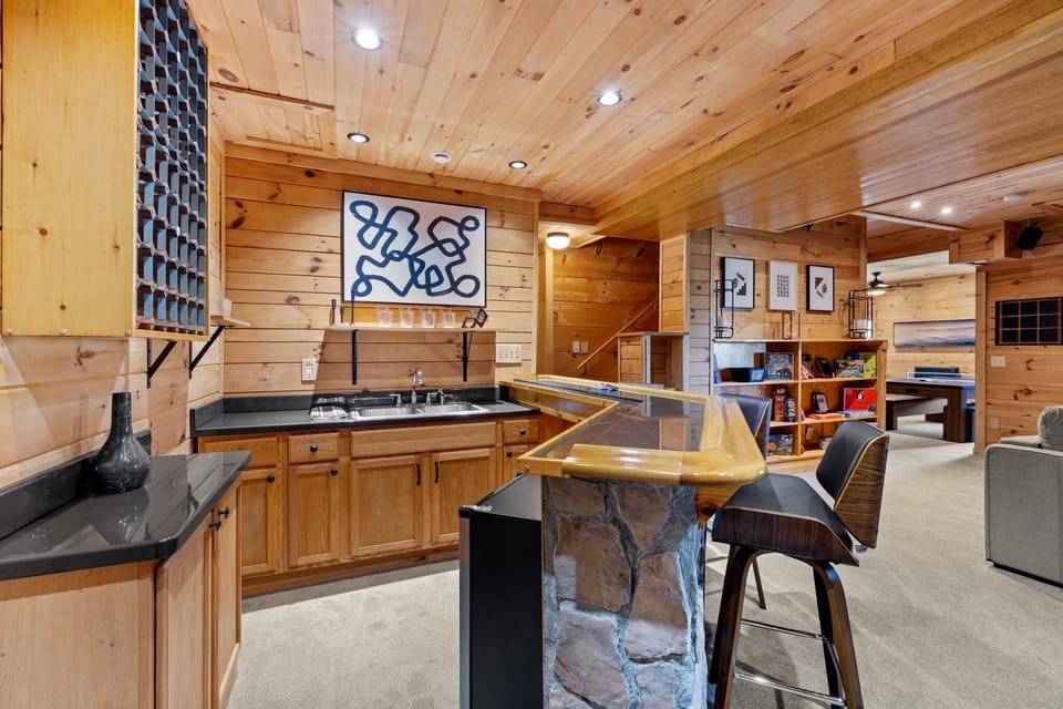 Full bar with mini fridge sink streching to staircase to main floor. 