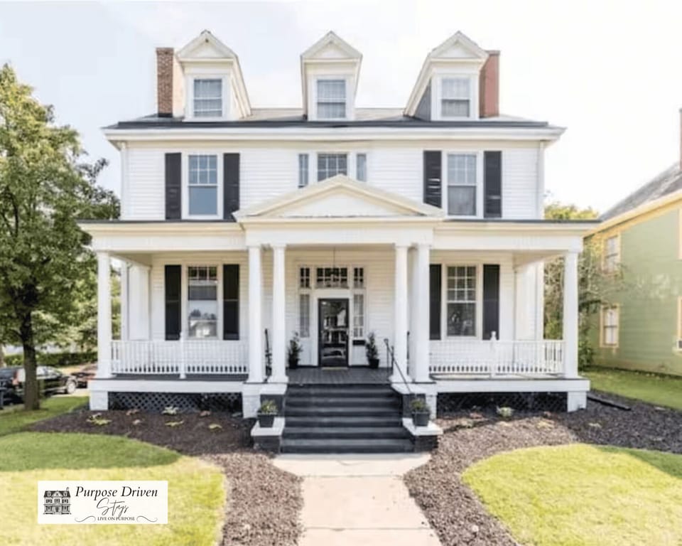 Stunning historic Victorian with beautiful front porch and rocking chairs.
