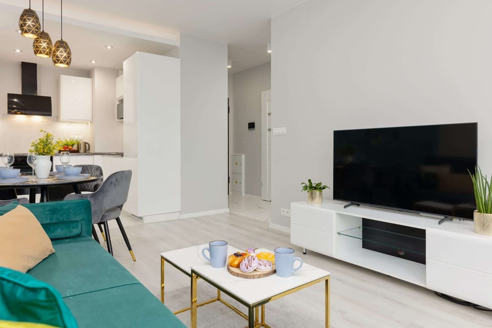 A living space with a modern TV console and large windows for natural lighting.
