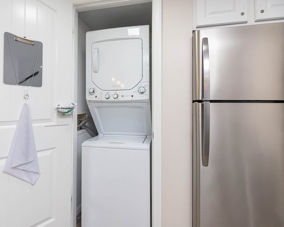 The laundry area features a stacked washer and dryer, a stainless refrigerator, perfect for convenience during your stay
