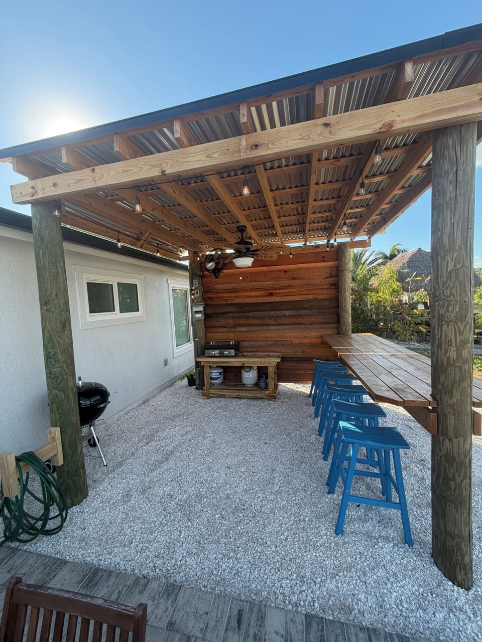 Pergola with bar seating for 6 and blackstone griddle. Outdoor fans and lighting