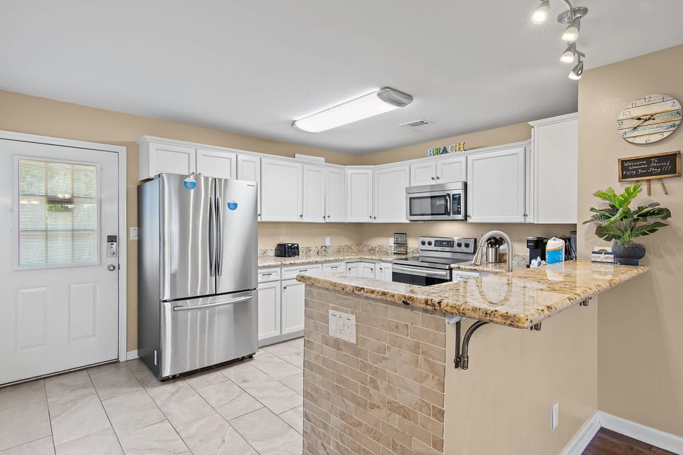 "A fully equipped kitchen with stainless steel appliances, granite countertops, and a breakfast bar — everything you need to cook up your favorite meals.