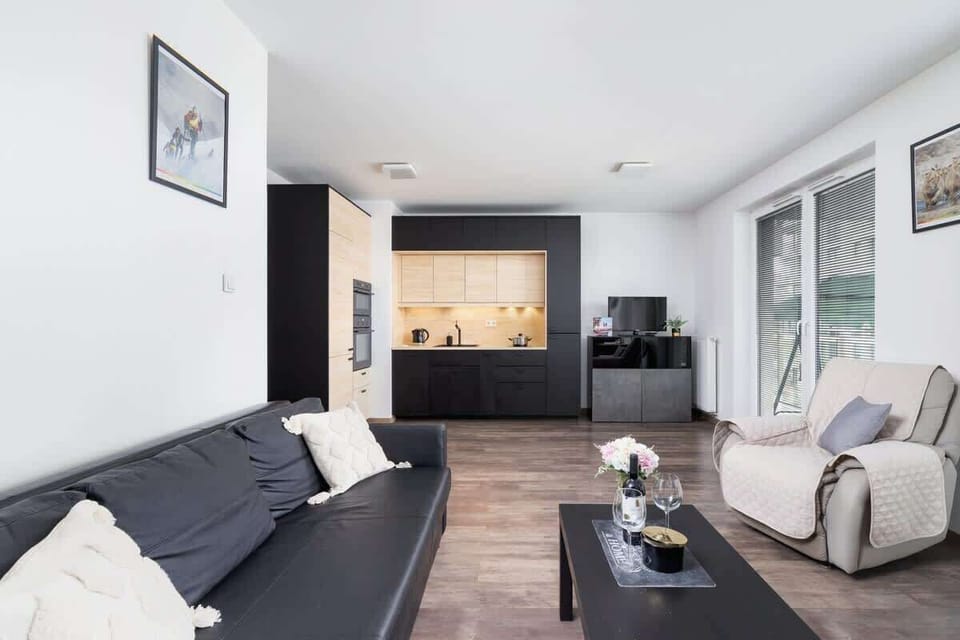 A comfortable living room with dark gray furniture and decorative cushions adding a cozy touch.
