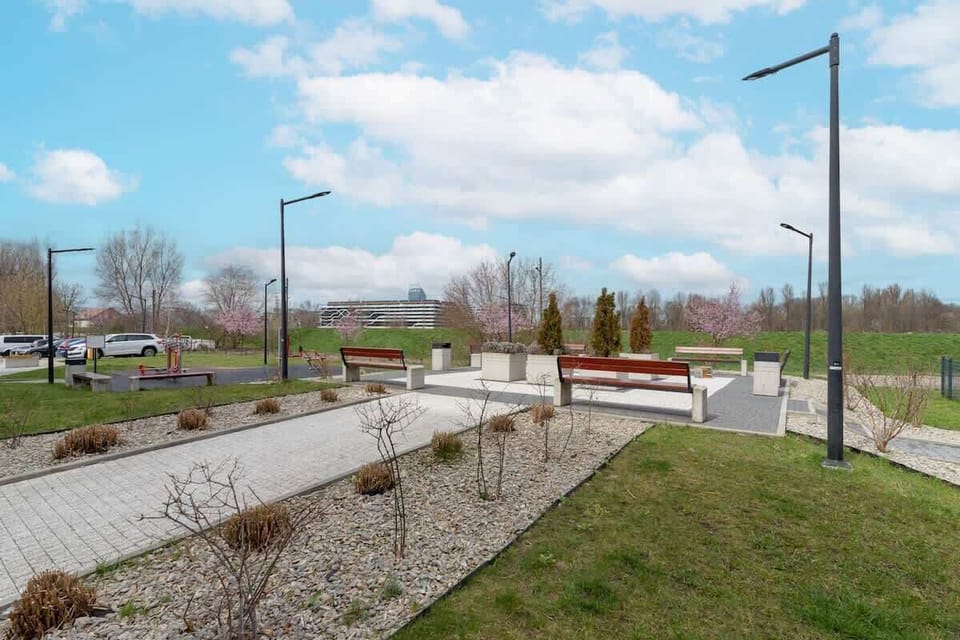 A walking path surrounded by greenery and outdoor seating, perfect for relaxation.
