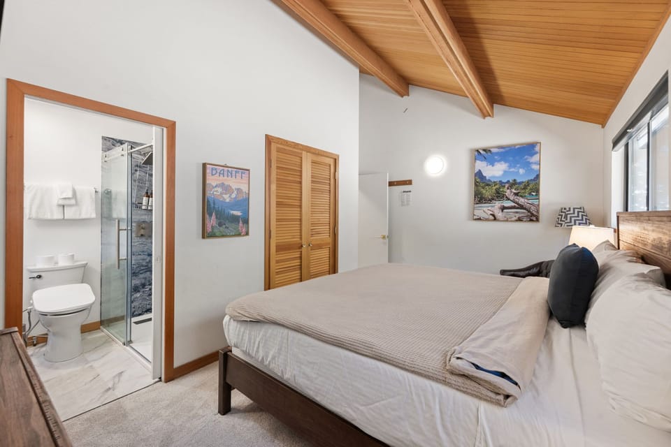 Unwind in your serene bedroom featuring exposed wood beams, crisp linens, and an ensuite bathroom for complete privacy and comfort.
