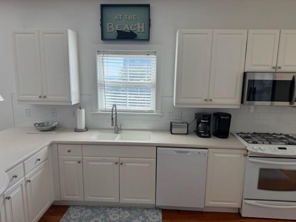 Your bright, fully-equipped kitchen invites morning coffee brewing and meal prep, with coastal charm and everything you need.