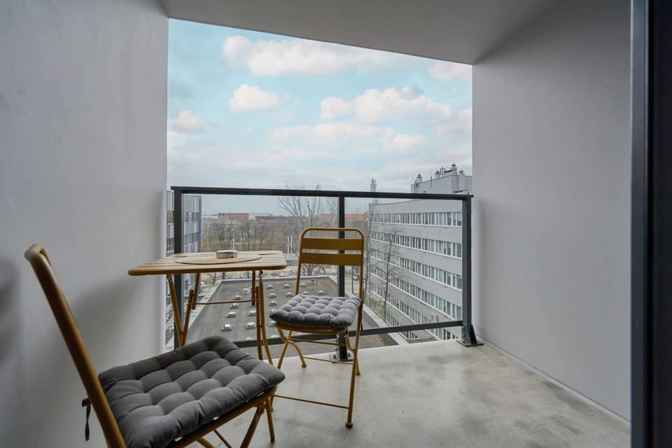 A private balcony with a table and chairs, offering a view of the surrounding area.
