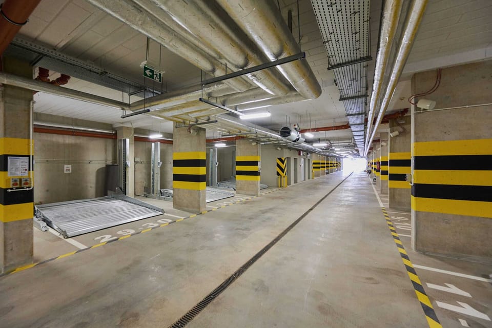 A spacious and well-lit parking garage with secure spaces and clear markings.
