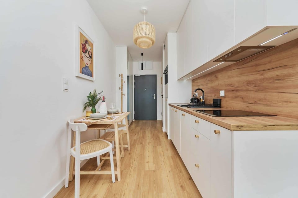 A modern kitchen with wooden countertops, white cabinets, and a spacious layout.
