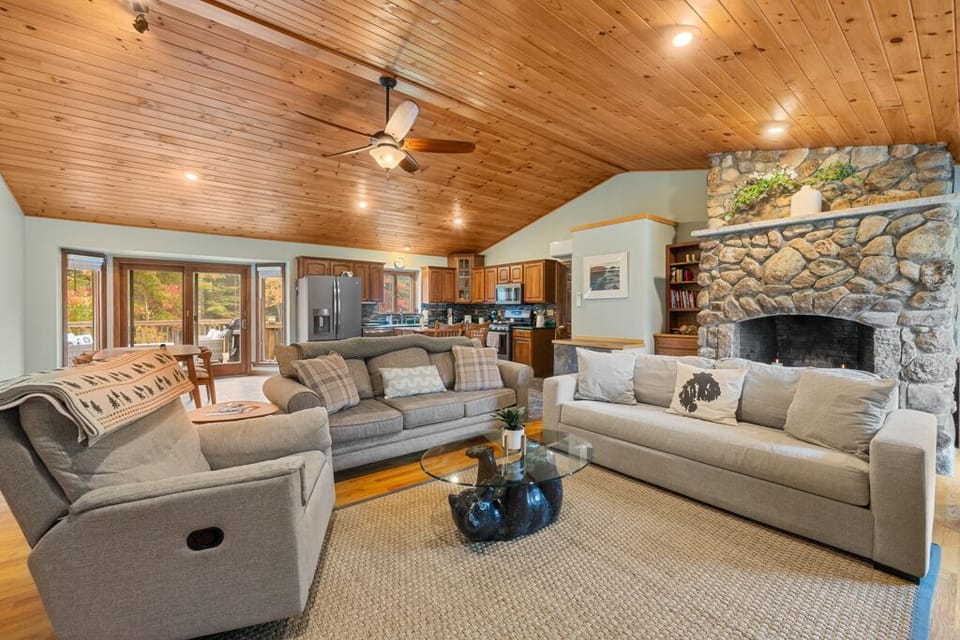 Open-concept kitchen, living, and dining space with high ceilings.