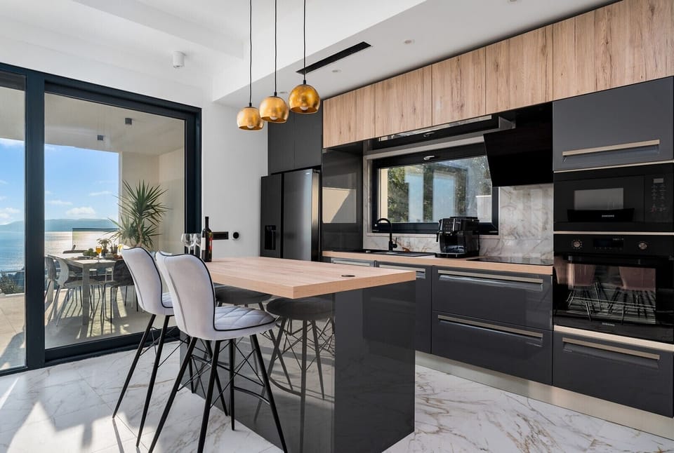 The living area is connected by an outdoor dining area and the pool area by glass floor-to-ceiling doors. 