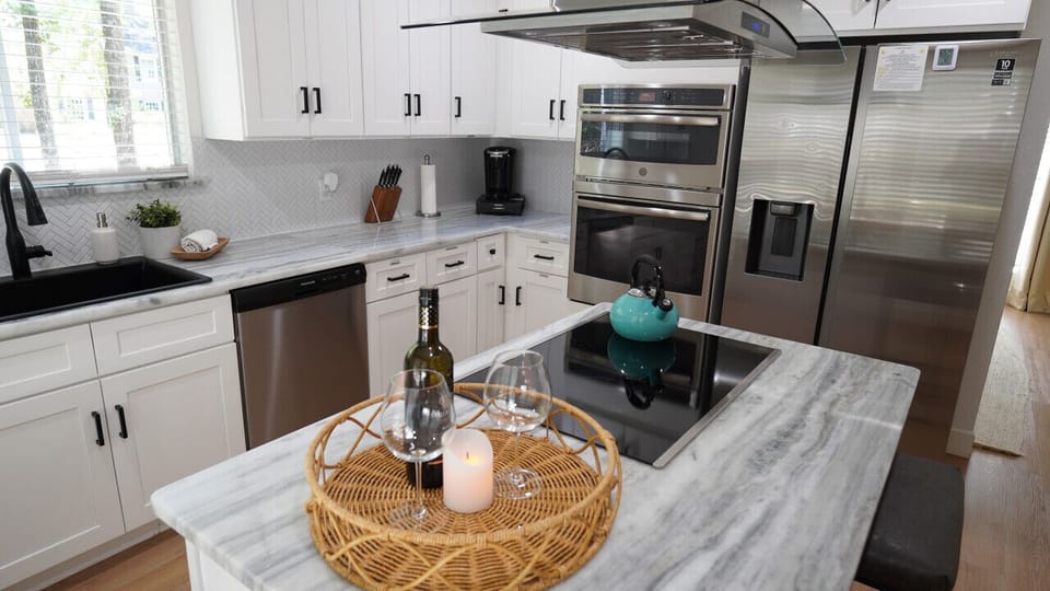 `Chef`s Delight in a Cozy Corner: This modern kitchen blends sleek design with homely comfort, perfect for both the ambitious home chef and those who love to entertain. Marble countertops and state-of-the-art appliances await in your home away from home. 