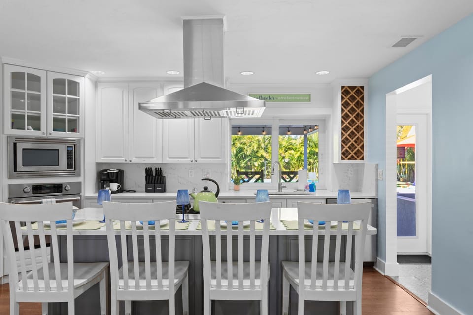 Kitchen Island: Bright counters with palm-view windows and bar seating for 4 — your morning coffee spot awaits.