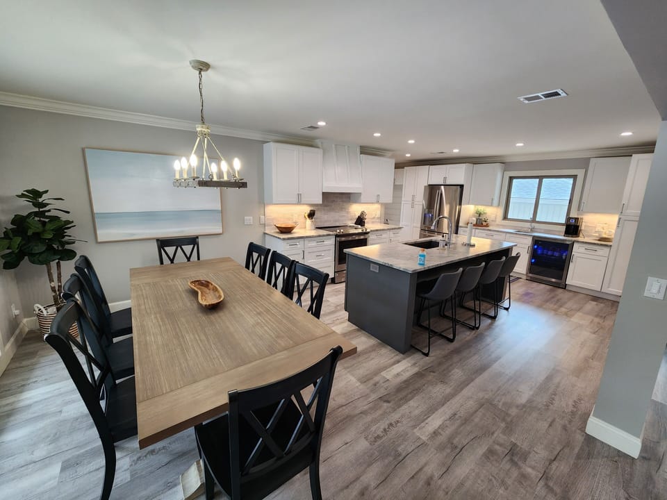Open bright kitchen & dining. Table seats 8 plus 4 chairs at kitchen island.