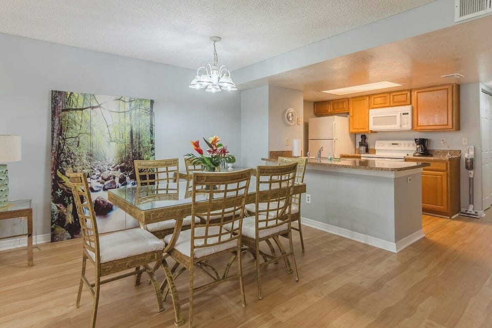 Dining room and frontal view of kitchen equipped with dishwasher, food pantry, toaster, coffee refrigerator, stove and oven with cooking appliances