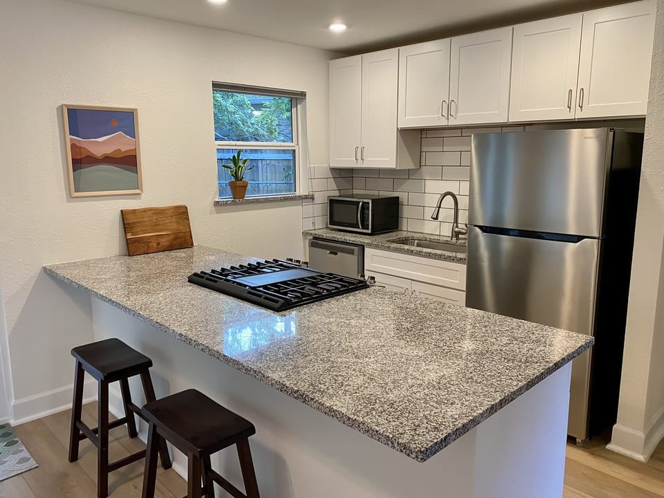 Renovated kitchen with updated cabinets and large granite island