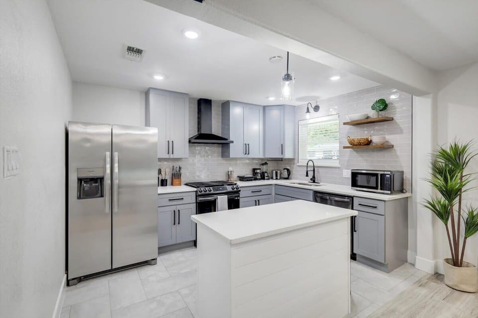 With plenty of natural sunlight to highlight the luxurious finishes throughout, this kitchen is a culinary delight with a stunning kitchen island and ample counter space.
