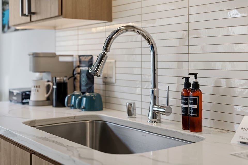 Prep your favorite meals in this modern kitchen with sleek countertops, subway tile backsplash, and high-quality fixtures ready for your culinary adventures.