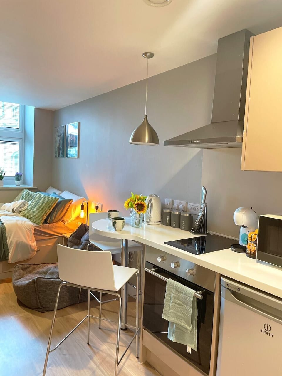 Modern kitchen with hob, oven, microwave, kettle, and coffee machine.