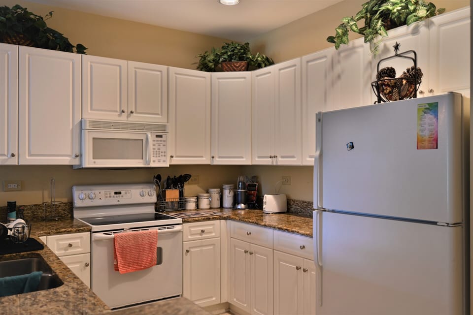 Bright kitchen with white cabinets, granite & modern, functional design.