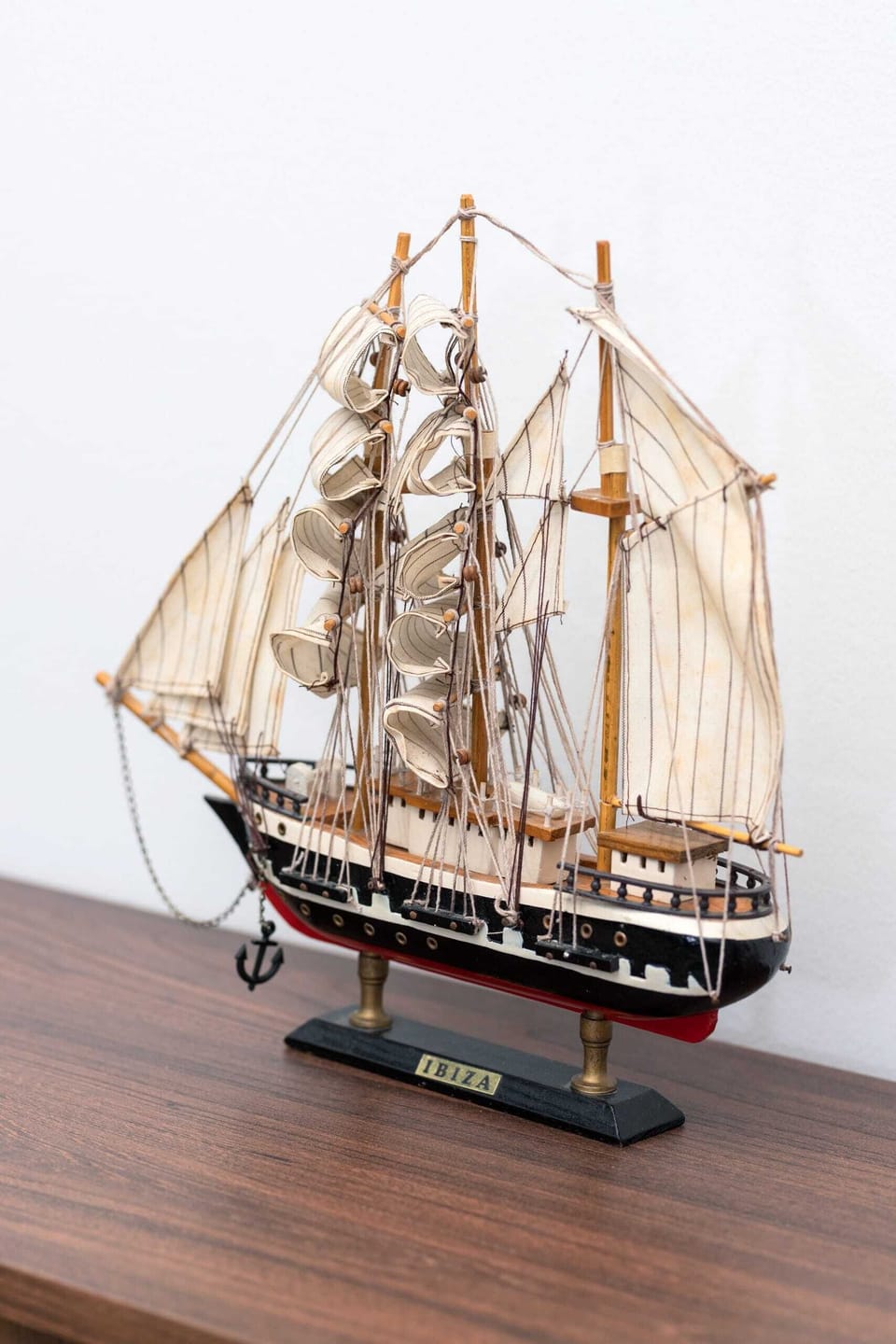A detailed ship model displayed on a sleek wooden surface. It adds a nautical charm to the interior decor.