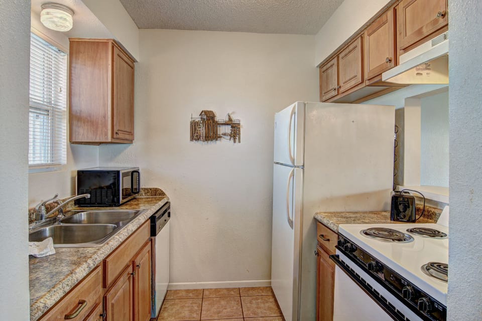 Your fully equipped galley kitchen features warm wood cabinets, granite counters, and everything needed to prepare meals during your stay.