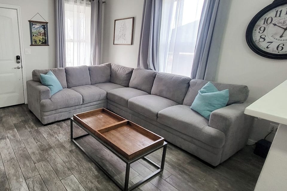 View of the comfortable living room towards the front door of the house. The drapes can be closed at night for privacy.