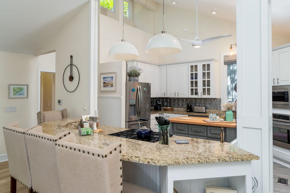 The kitchen is open to the dining area. The island has seating for three.