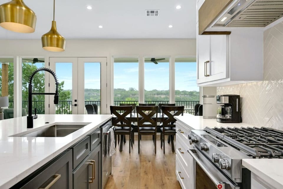 Cook, snack, and linger a little longer—family-friendly kitchen and dining with lake view windows, perfect for groups in Spicewood.