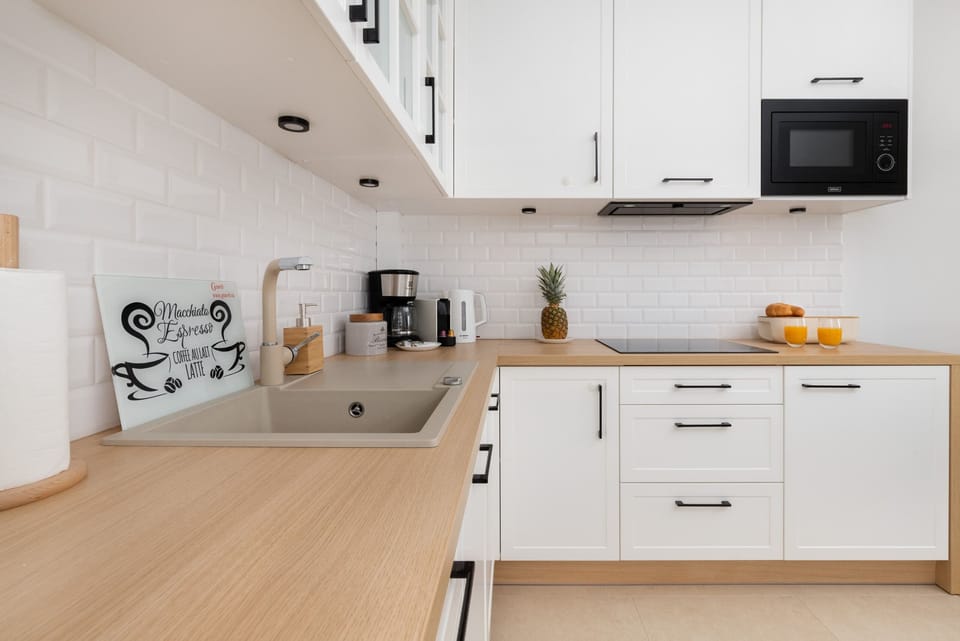 Stylish kitchen with a wooden countertop, modern appliances, and a clean, minimalist design.
