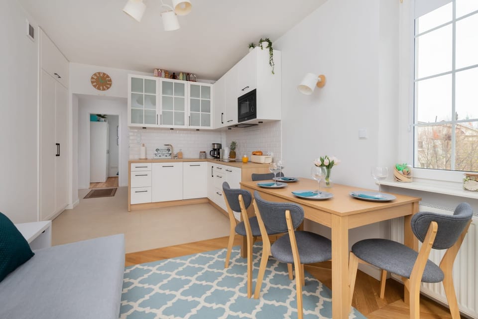 Dining area with a spacious table, wooden chairs, and plenty of natural light, ideal for shared meals.
