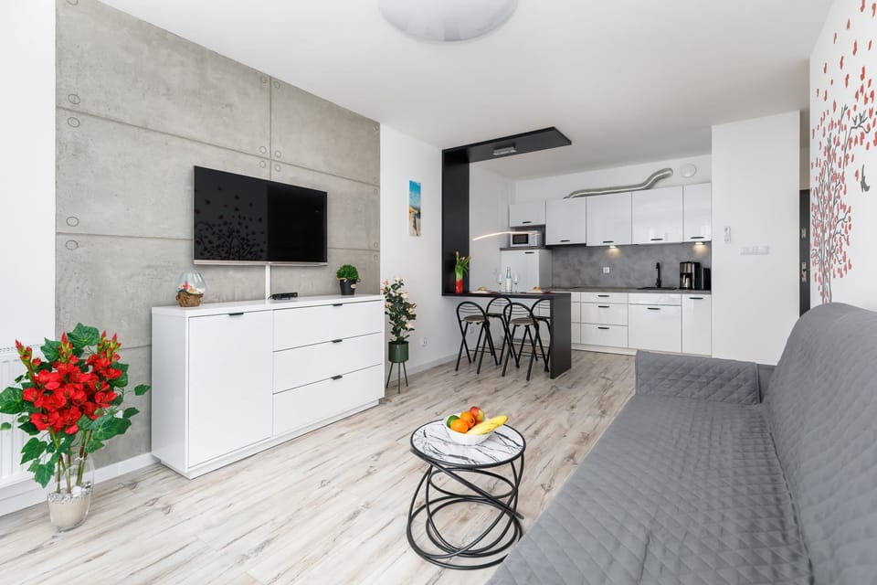 Open-plan living and dining area with a modern sofa, coffee table, and decorative accents for added charm.
