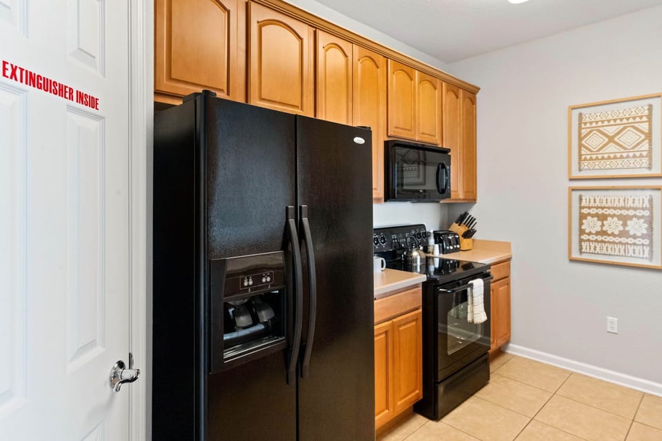 Step into the sleek sophistication of our fully equipped kitchen, where black and brown hues harmonize effortlessly.