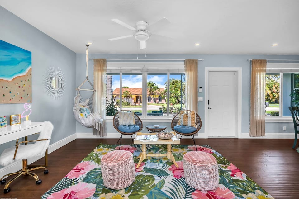 As you enter the home, beauty surrounds you. The entry room/ office is a smaller sitting area with a 3- piece Acapulco natural bistro set, topped with sky blue and Boho yellow throw pillows. These sit on an exquisite SAFAVIEH Barbados tropical rug.