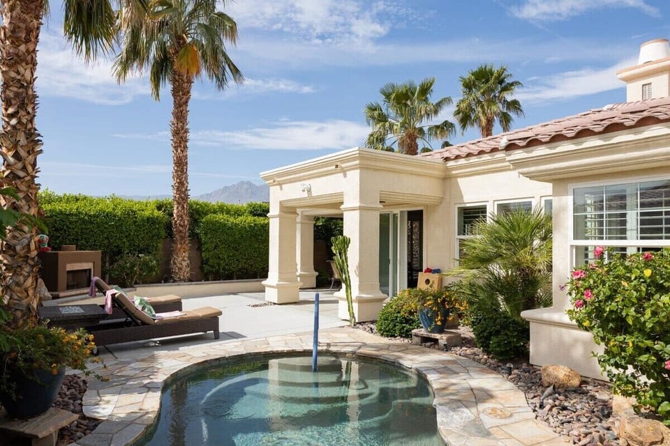 The backyard pool with sun loungers to sunbathe.