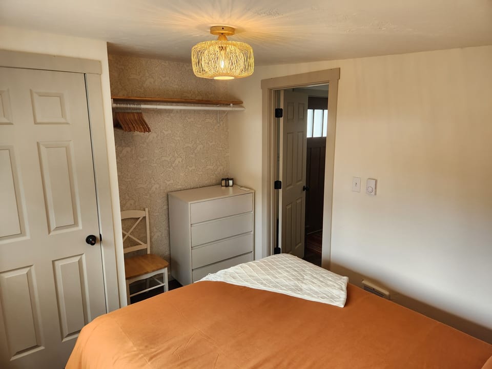 Bedroom: open closet w/hangers and dresser. 