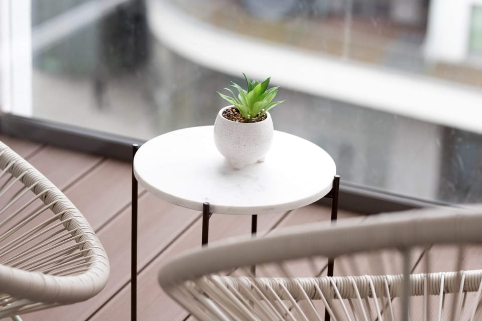 Close-up of the balcony table with a small plant, creating a refreshing and natural vibe in the outdoor space.
