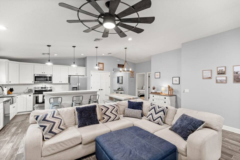 Bright, open-concept living area with plush sectional seating and modern kitchen—perfect for relaxin
